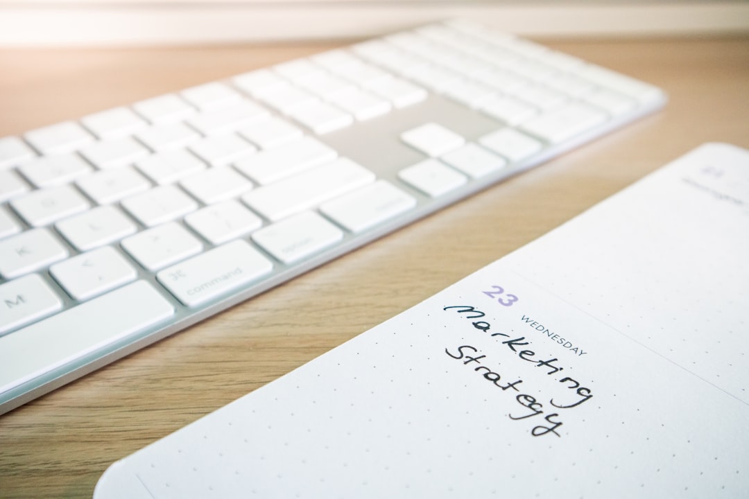 Desk with a keyboard and a planner with the words Marketing Strategy on it